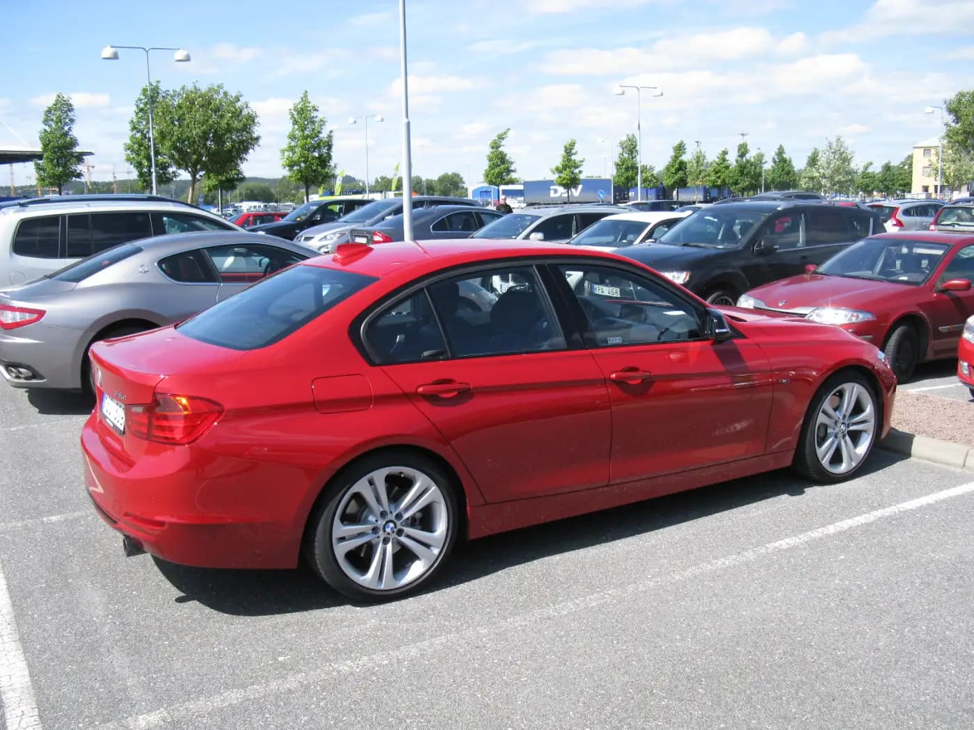 Red BMW 335i sedan, rear three-quarter view