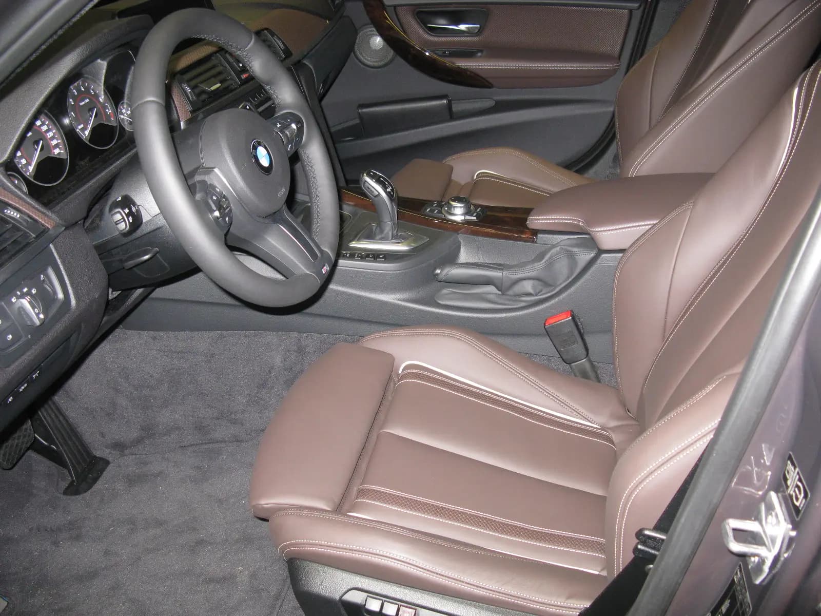 BMW 335i sedan interior with leather sport seats, dashboard and steering wheel