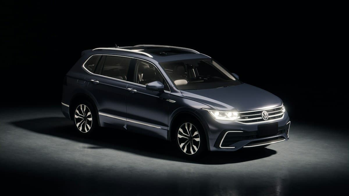 A dark grey Volkswagen Tiguan SUV in a dark studio.